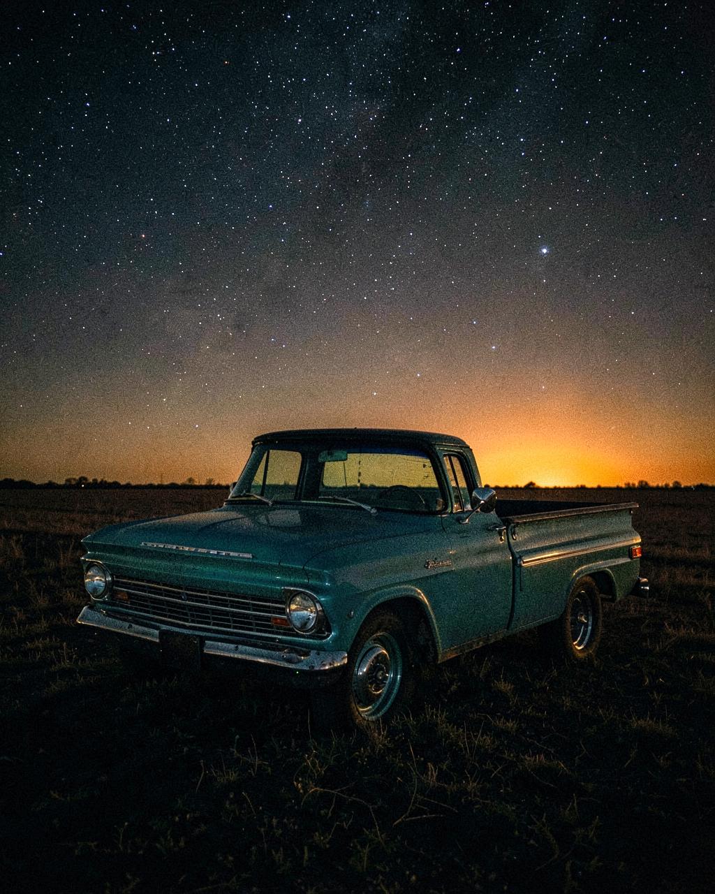 Vintage 1968 Chevy pickup parked in a field under stars